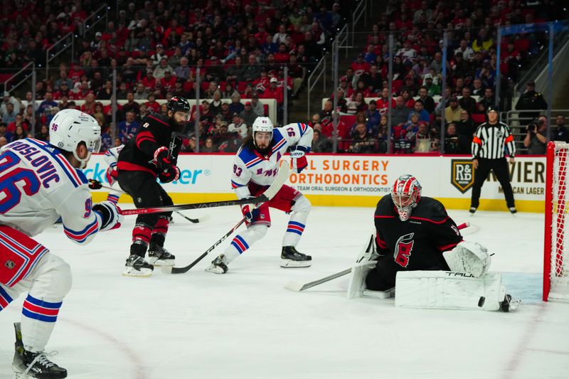 Mar 12, 2024; Raleigh, North Carolina, USA; Carolina Hurricanes goaltender Pyotr Kochetkov (52) stops the shot by New York Rangers center Jack Roslovic (96) during the second period at PNC Arena. Mandatory Credit: James Guillory-USA TODAY Sports