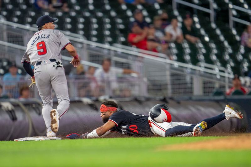 Aug 26, 2024; Minneapolis, Minnesota, USA; Minnesota Twins shortstop Willi Castro (50) slides into third base before Atlanta Braves third baseman Gio Urshela (9) can catch the ball and make a tag in the fifth inning at Target Field. Mandatory Credit: Jesse Johnson-USA TODAY Sports