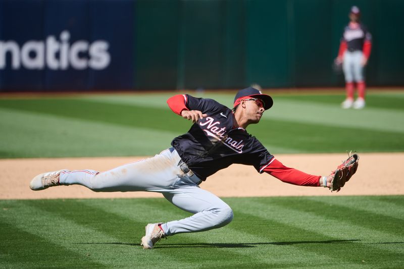 Apr 14, 2024; Oakland, California, USA; Washington Nationals third baseman Trey Lipscomb (38) falls after catching a fly ball in the  infield against the Oakland Athletics during the eighth inning at Oakland-Alameda County Coliseum. Mandatory Credit: Robert Edwards-USA TODAY Sports