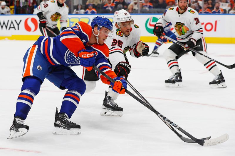 Oct 12, 2024; Edmonton, Alberta, CAN; Edmonton Oilers forward Connor McDavid (97) tries to carry the puck around Chicago Blackhawks defensemen Alec Martinez (25) during the first period at Rogers Place. Mandatory Credit: Perry Nelson-Imagn Images