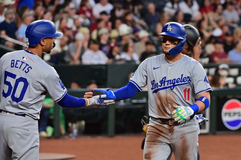 May 1, 2024; Phoenix, Arizona, USA;  Los Angeles Dodgers shortstop Miguel Rojas (11) celebrates with shortstop Mookie Betts (50) after scoring in the second inning against the Arizona Diamondbacks at Chase Field. Mandatory Credit: Matt Kartozian-USA TODAY Sports