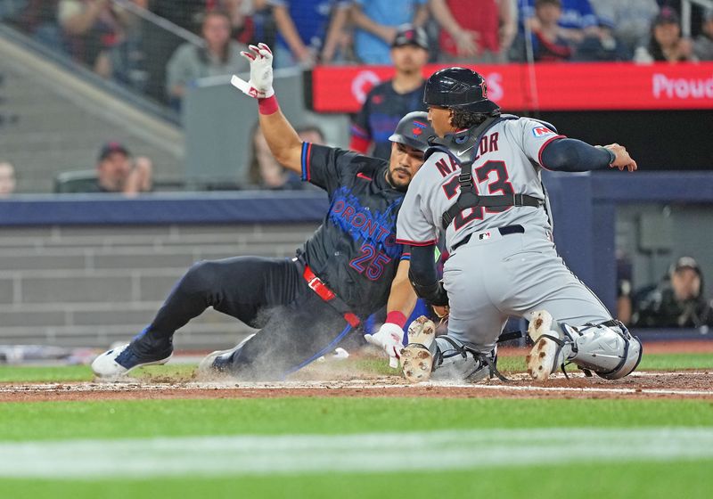May 2, 2025; Toronto, Ontario, CAN; Toronto Blue Jays left ielder Anthony Santander (25) slides into home ahead of the tag from Cleveland Guardians catcher Bo Naylor (23) during the third inning at Rogers Centre. Mandatory Credit: Nick Turchiaro-Imagn Images