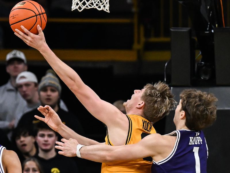 Feb 8, 2026; Iowa City, Iowa, USA; Iowa Hawkeyes forward Cooper Koch (8) is defended by Northwestern Wildcats forward Tyler Kropp (1) during the first half at Carver-Hawkeye Arena. Mandatory Credit: Jeffrey Becker-Imagn Images