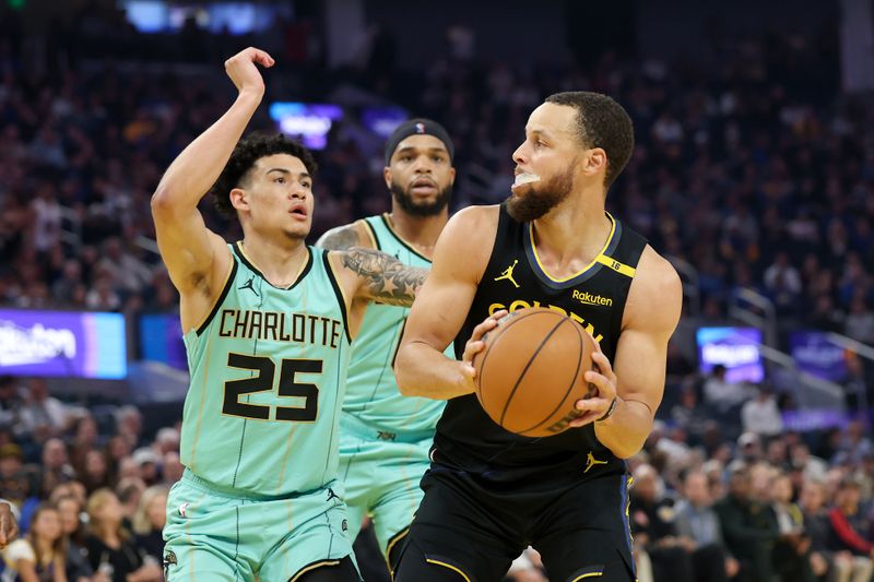 SAN FRANCISCO, CALIFORNIA - FEBRUARY 25: Stephen Curry #30 of the Golden State Warriors is guarded by KJ Simpson #25 of the Charlotte Hornets during the first half at Chase Center on February 25, 2025 in San Francisco, California. NOTE TO USER: User expressly acknowledges and agrees that, by downloading and/or using this photograph, user is consenting to the terms and conditions of the Getty Images License Agreement.   (Photo by Ezra Shaw/Getty Images)