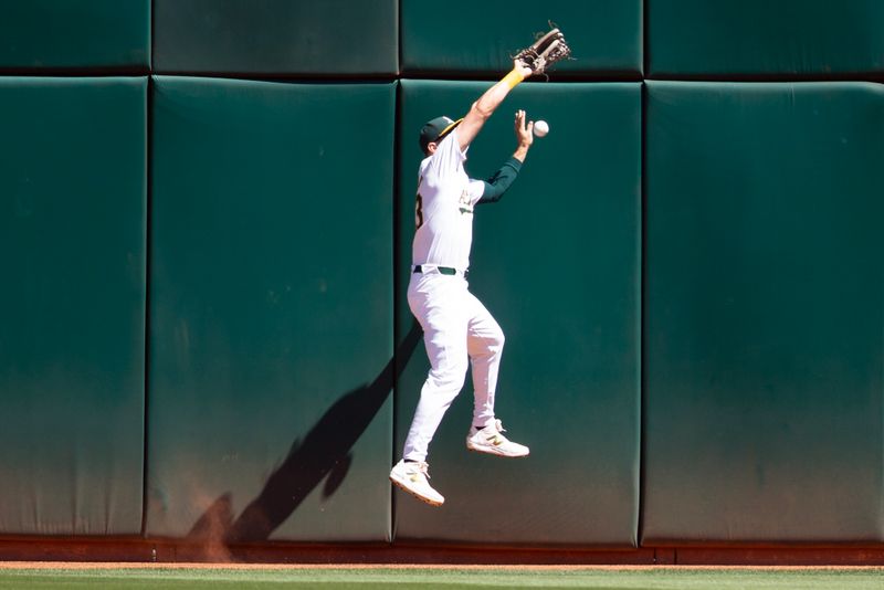 Sep 5, 2024; Oakland, California, USA; Oakland Athletics center fielder JJ Bleday (33) cannot make the catch of a double off the wall by Seattle Mariners first baseman Luke Raley(not pictured) during the fifth inning at Oakland-Alameda County Coliseum. Mandatory Credit: D. Ross Cameron-Imagn Images