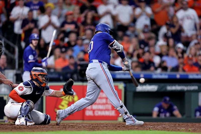 Jul 13, 2024; Houston, Texas, USA; Texas Rangers first baseman Nathaniel Lowe (30) hits an RBI single against the Houston Astros during the tenth inning at Minute Maid Park. Mandatory Credit: Erik Williams-USA TODAY Sports