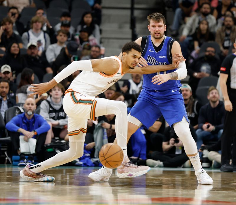 SAN ANTONIO, TX - MARCH 19:  Victor Wembanyama #1 of the San Antonio Spurs tries to save the ball after Luka Doncic #77 of the Dallas Mavericks knocked it away from him in the second half at Frost Bank Center on March 19, 2024 in San Antonio, Texas. NOTE TO USER: User expressly acknowledges and agrees that, by downloading and or using this photograph, User is consenting to terms and conditions of the Getty Images License Agreement. (Photo by Ronald Cortes/Getty Images)