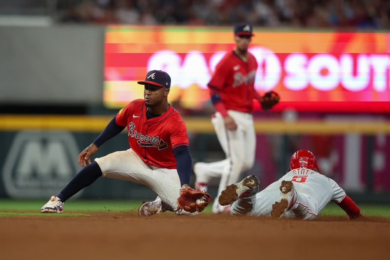 Jul 5, 2024; Atlanta, Georgia, USA; Philadelphia Phillies designated hitter Bryson Stott (5) steals second past Atlanta Braves second baseman Ozzie Albies (1) in the seventh inning at Truist Park. Mandatory Credit: Brett Davis-USA TODAY Sports