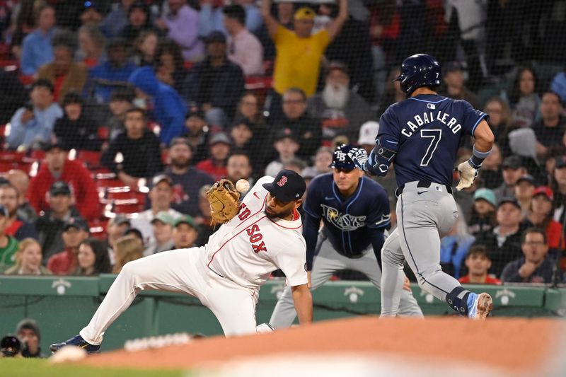 May 16, 2024; Boston, Massachusetts, USA; Boston Red Sox first baseman Dominic Smith (2) can't make a catch at first base against Tampa Bay Rays shortstop Jose Caballero (7) during the fourth inning at Fenway Park. Mandatory Credit: Eric Canha-USA TODAY Sports