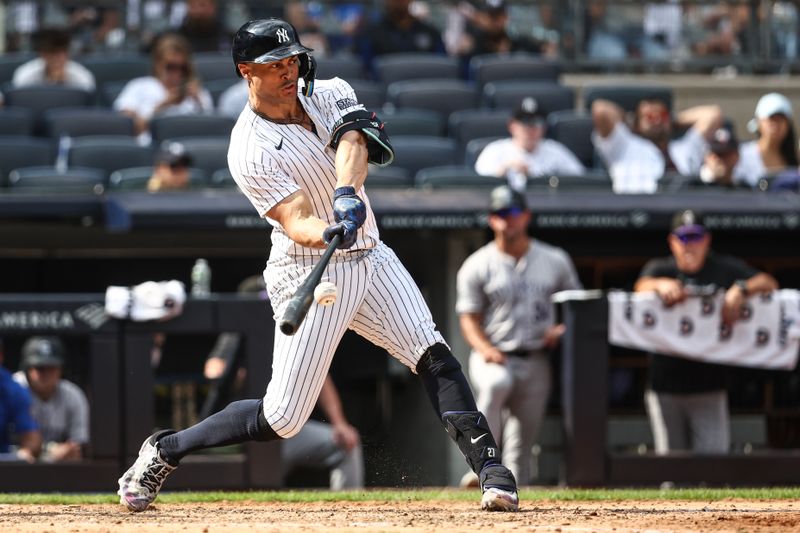 Aug 25, 2024; Bronx, New York, USA;  New York Yankees designated hitter Giancarlo Stanton (27) hits a solo home run in the seventh inning against the Colorado Rockies at Yankee Stadium. Mandatory Credit: Wendell Cruz-USA TODAY Sports