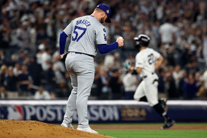 Oct 30, 2024; New York, New York, USA; Los Angeles Dodgers pitcher Ryan Brasier (57) reacts after giving up a home run to New York Yankees designated hitter Giancarlo Stanton (27) during the third inning in game five of the 2024 MLB World Series at Yankee Stadium. Mandatory Credit: Vincent Carchietta-Imagn Images