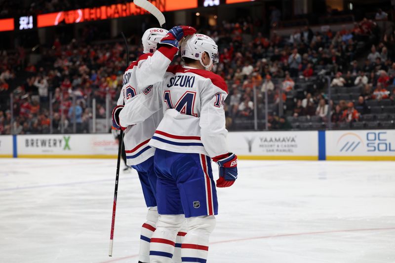 Mar 6, 2026; Anaheim, California, USA;  Montreal Canadiens center Nick Suzuki (14) celebrates with defenseman Noah Dobson (left) after scoring a goal against the Anaheim Ducks during the first period at Honda Center. Mandatory Credit: Kiyoshi Mio-Imagn Images