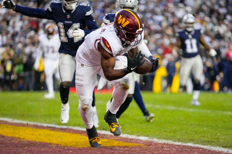 Washington Commanders running back Brian Robinson Jr. (8) holds onto the ball to score a touchdown against the Dallas Cowboys during the first half of an NFL football game, Sunday, Jan. 7, 2024, in Landover, Md. (AP Photo/Mark Schiefelbein)