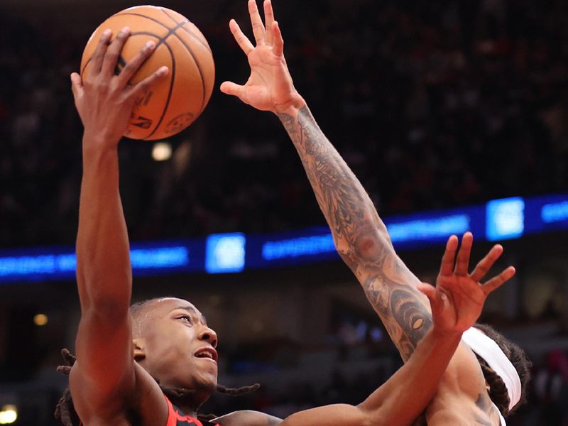 CHICAGO, ILLINOIS - JANUARY 30: Ayo Dosunmu #12 of the Chicago Bulls goes up for a layup against the Toronto Raptors during the first half at the United Center on January 30, 2024 in Chicago, Illinois. NOTE TO USER: User expressly acknowledges and agrees that, by downloading and or using this photograph, User is consenting to the terms and conditions of the Getty Images License Agreement.  (Photo by Michael Reaves/Getty Images)