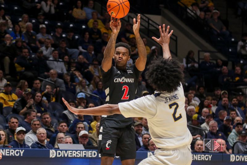 Jan 6, 2026; Morgantown, West Virginia, USA; Cincinnati Bearcats guard Jizzle James (2) shoots a three-point shot over West Virginia Mountaineers guard Amir Jenkins (2) during the first half at Hope Coliseum. Mandatory Credit: Ben Queen-Imagn Images