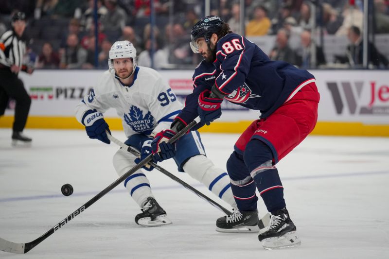 Oct 22, 2024; Columbus, Ohio, USA; Columbus Blue Jackets right wing Kirill Marchenko (86) skates for the puck against Toronto Maple Leafs defenseman Oliver Ekman-Larsson (95) during the first period at Nationwide Arena. Mandatory Credit: Aaron Doster-Imagn Images