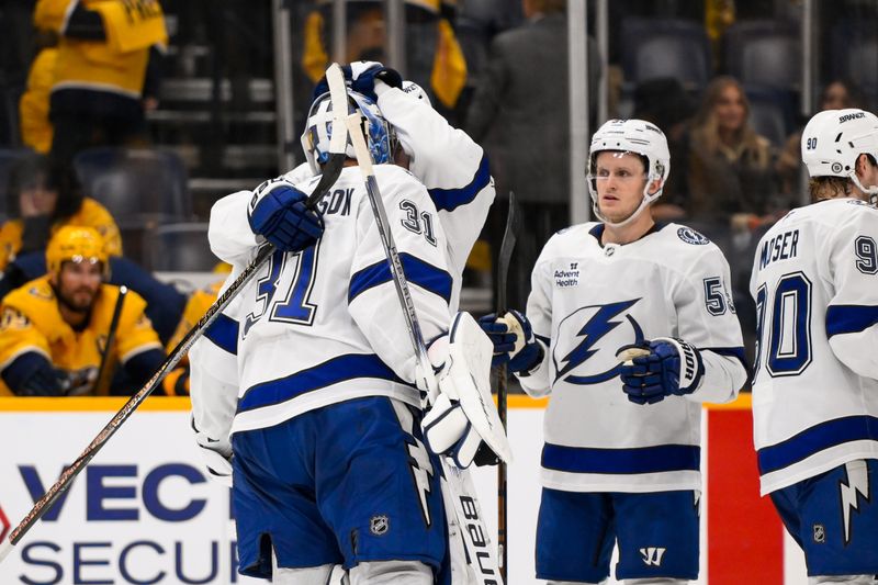 Nov 29, 2024; Nashville, Tennessee, USA;  Tampa Bay Lightning goaltender Jonas Johansson (31) celebrates the win with his teammates against the Nashville Predators during the overtime period at Bridgestone Arena. Mandatory Credit: Steve Roberts-Imagn Images