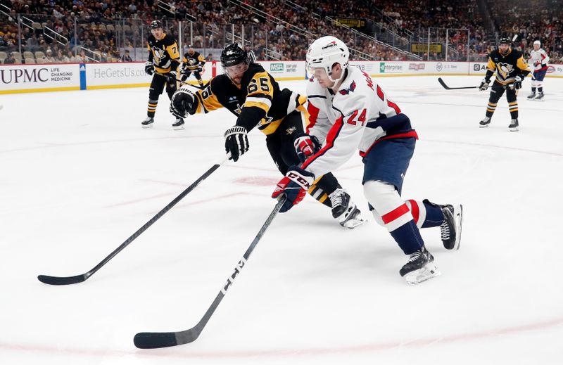 Jan 2, 2024; Pittsburgh, Pennsylvania, USA;  Washington Capitals center Connor McMichael (24) skates in on goal with the puck as Pittsburgh Penguins defenseman Erik Karlsson (65) defends during the second period at PPG Paints Arena. Mandatory Credit: Charles LeClaire-USA TODAY Sports