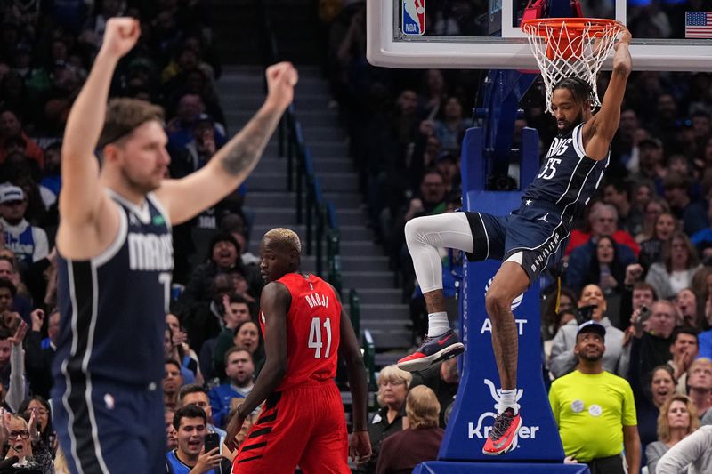 DALLAS, TEXAS - JANUARY 03: Derrick Jones Jr. #55 of the Dallas Mavericks hangs on the rim after dunking the ball during the first half against the Portland Trail Blazers at American Airlines Center on January 03, 2024 in Dallas, Texas. NOTE TO USER: User expressly acknowledges and agrees that, by downloading and or using this photograph, User is consenting to the terms and conditions of the Getty Images License Agreement. (Photo by Sam Hodde/Getty Images)