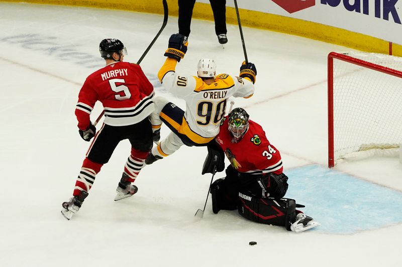 Oct 25, 2024; Chicago, Illinois, USA; Chicago Blackhawks defenseman Connor Murphy (5) goaltender Petr Mrazek (34) defend Nashville Predators center Ryan O'Reilly (90) during the third period at the United Center. Mandatory Credit: David Banks-Imagn Images