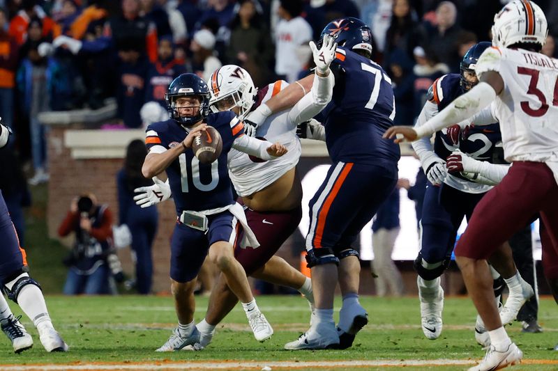 Nov 25, 2023; Charlottesville, Virginia, USA; Virginia Cavaliers quarterback Anthony Colandrea (10) scrambles from Virginia Tech Hokies defensive lineman Josh Fuga (6) during the second quarter at Scott Stadium. Mandatory Credit: Geoff Burke-USA TODAY Sports