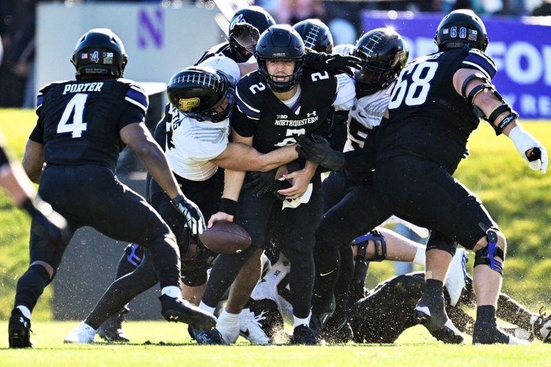 Nov 18, 2023; Evanston, Illinois, USA;  Northwestern Wildcats quarterback Ben Bryant (2) passes the ball to running back Cam Porter (4) before being sacked in the first quarter against the Purdue Boilermakers  at Ryan Field. Mandatory Credit: Jamie Sabau-USA TODAY Sports