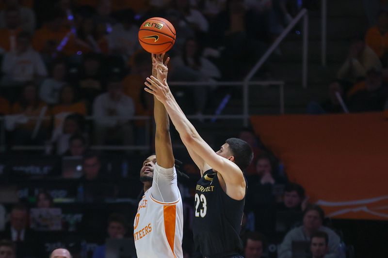 Feb 17, 2024; Knoxville, Tennessee, USA; Tennessee Volunteers forward Jonas Aidoo (0) blocks a shot from Vanderbilt Commodores guard Jason Rivera-Torres (23) during the second half at Thompson-Boling Arena at Food City Center. Mandatory Credit: Randy Sartin-USA TODAY Sports