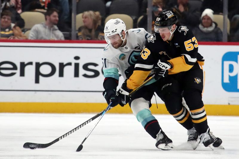 Jan 14, 2025; Pittsburgh, Pennsylvania, USA;  Pittsburgh Penguins center Philip Tomasino (53) moves the puck against pressure rom Seattle Kraken center Shane Wright (51) during the third period at PPG Paints Arena. Mandatory Credit: Charles LeClaire-Imagn Images