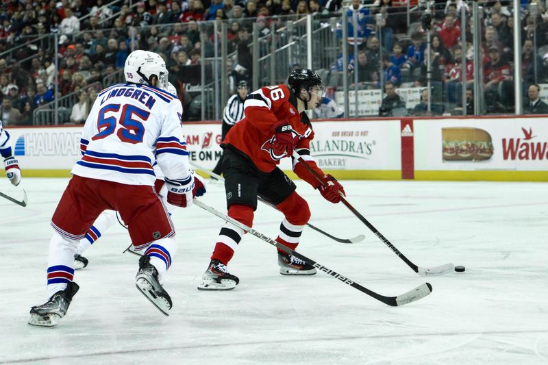 Feb 22, 2024; Newark, New Jersey, USA; New Jersey Devils center Jack Hughes (86) skates with the puck while being defended by New York Rangers defenseman Ryan Lindgren (55) during the second period at Prudential Center. Mandatory Credit: John Jones-USA TODAY Sports