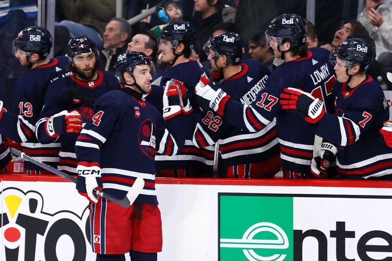 Dec 20, 2023; Winnipeg, Manitoba, CAN; Winnipeg Jets defenseman Neal Pionk (4) celebrates his first period goal against the Detroit Red Wings at Canada Life Centre. Mandatory Credit: James Carey Lauder-USA TODAY Sports