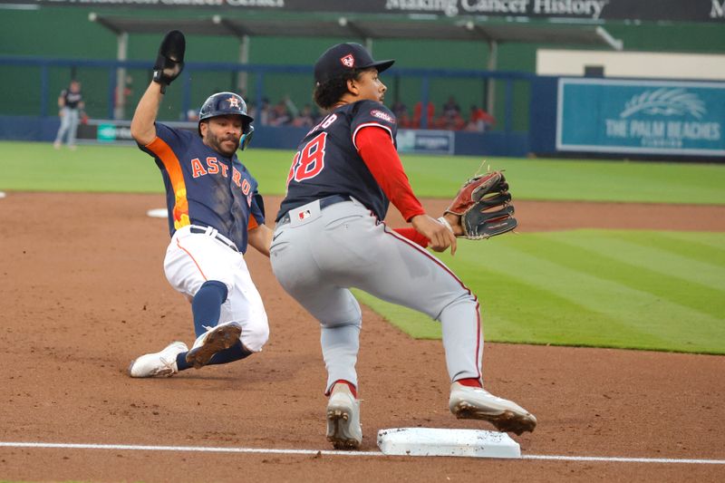 Mar 18, 2024; West Palm Beach, Florida, USA;  Houston Astros second baseman Jose Altuve (27) slides safely into third base as Washington Nationals third baseman Trey Lipscomb (38) waits on the ball to arrive during the third inning at The Ballpark of the Palm Beaches. Mandatory Credit: Reinhold Matay-USA TODAY Sports