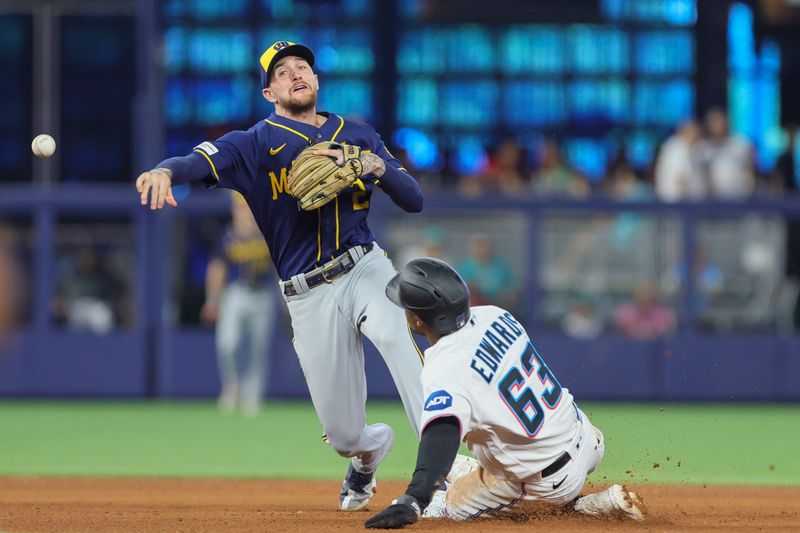 Sep 24, 2023; Miami, Florida, USA; Milwaukee Brewers second baseman Brice Turang (2) turns a double play as Miami Marlins second baseman Xavier Edwards (63) slides at second base during the fourth inning at loanDepot Park. Mandatory Credit: Sam Navarro-USA TODAY Sports