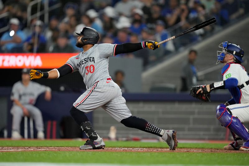 May 10, 2024; Toronto, Ontario, CAN; Minnesota Twins first baseman Carlos Santana (30) hits a solo home run against the Toronto Blue Jays during the fifth inning at Rogers Centre. Mandatory Credit: John E. Sokolowski-USA TODAY Sports