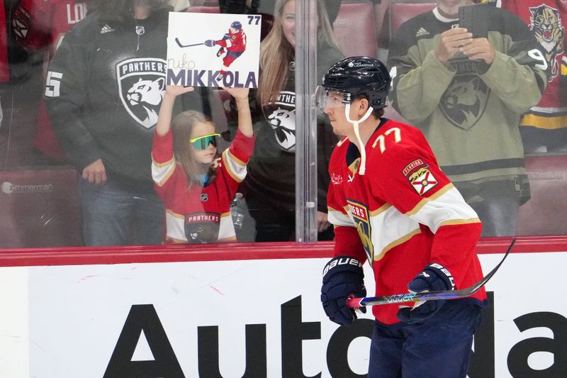 Nov 10, 2023; Sunrise, Florida, USA; Florida Panthers defenseman Niko Mikkola (77) skates by a young fan holding a sign for him prior to the game against the Carolina Hurricanes at Amerant Bank Arena. Mandatory Credit: Jasen Vinlove-USA TODAY Sports