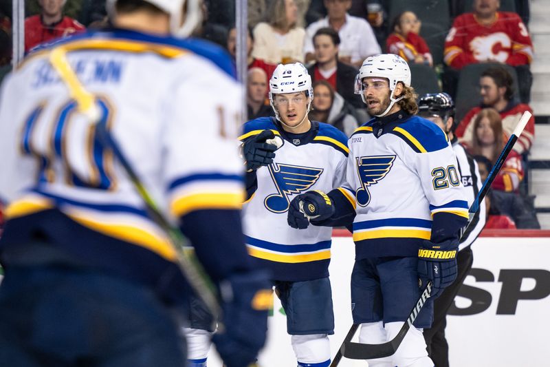 Dec 5, 2024; Calgary, Alberta, CAN; St. Louis Blues center Zachary Bolduc (76) celebrates with left wing Brandon Saad (20), center Brayden Schenn (10) and teammates after scoring a goal against the Calgary Flames during the first period at Scotiabank Saddledome. Mandatory Credit: Brett Holmes-Imagn Images