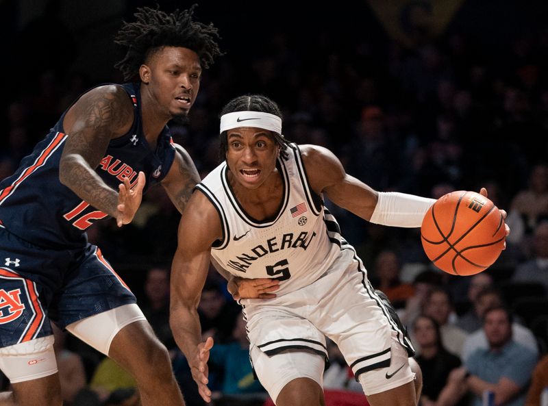 Feb 18, 2023; Nashville, Tennessee, USA;   Vanderbilt Commodores guard Ezra Manjon (5) drives against Auburn Tigers guard Zep Jasper (12) during the first half at Memorial Gymnasium.  Mandatory Credit: George Walker IV - USA TODAY Sports