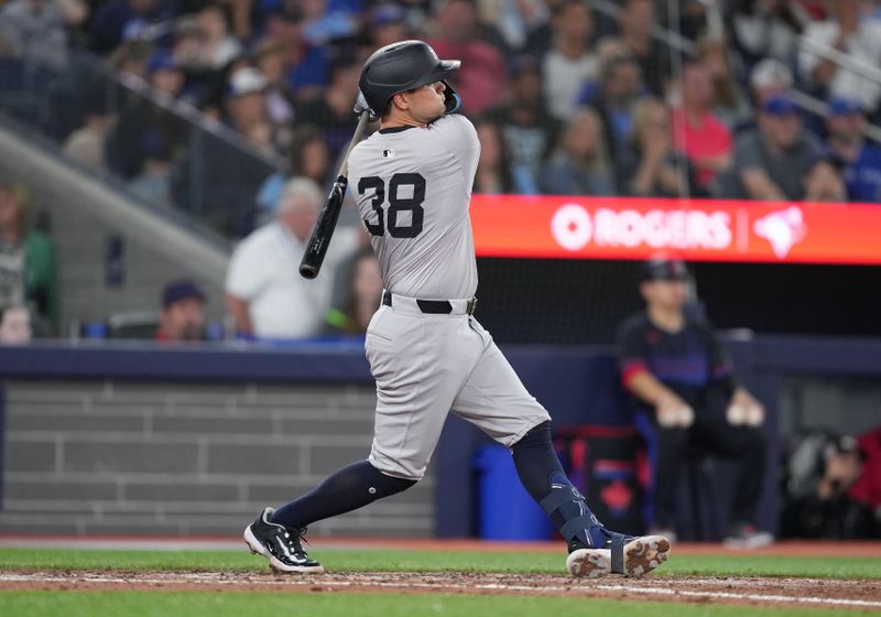 Jun 28, 2024; Toronto, Ontario, CAN; New York Yankees first baseman J.D. Davis (38) hits a RBI double against the Toronto Blue Jays during the sixth inning at Rogers Centre. Mandatory Credit: Nick Turchiaro-USA TODAY Sports