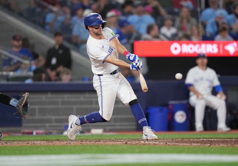 Jun 30, 2024; Toronto, Ontario, CAN; Toronto Blue Jays third baseman Ernie Clement (28) hits a single against the New York Yankees during the seventh inning at Rogers Centre. Mandatory Credit: Nick Turchiaro-USA TODAY Sports