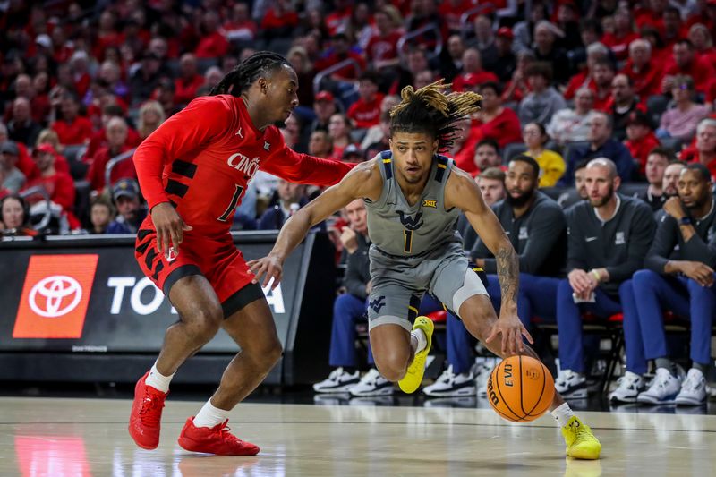 Mar 9, 2024; Cincinnati, Ohio, USA; West Virginia Mountaineers guard Noah Farrakhan (1) dribbles against Cincinnati Bearcats guard Day Day Thomas (1) in the second half at Fifth Third Arena. Mandatory Credit: Katie Stratman-USA TODAY Sports