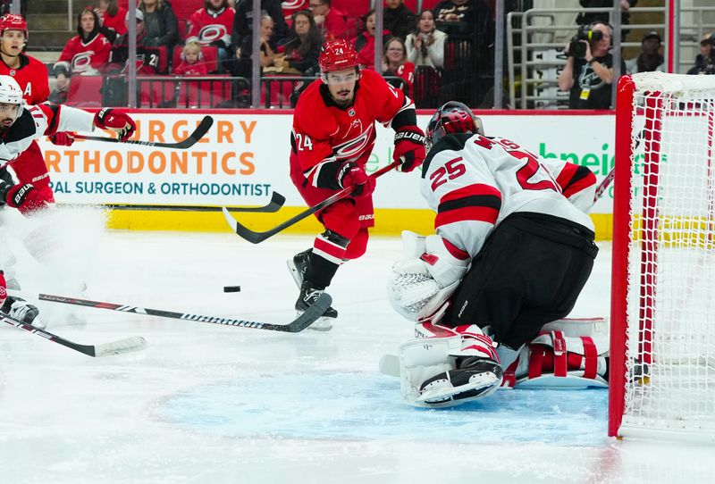 Oct 15, 2024; Raleigh, North Carolina, USA;  Carolina Hurricanes center Seth Jarvis (24) takes a shot on New Jersey Devils goaltender Jacob Markstrom (25) during the first period at PNC Arena. Mandatory Credit: James Guillory-Imagn Images