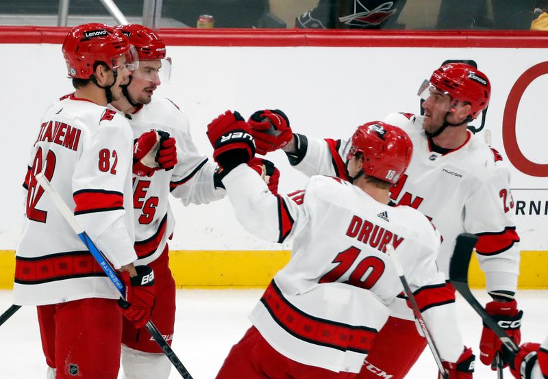 Mar 26, 2024; Pittsburgh, Pennsylvania, USA; Carolina Hurricanes center Jesperi Kotkaniemi (82) and defenseman Dmitry Orlov (left center) and center Jack Drury (18) and right wing Stefan Noesen (23) celebrate a goal by Orlov against the Pittsburgh Penguins during the second period at PPG Paints Arena. Mandatory Credit: Charles LeClaire-USA TODAY Sports