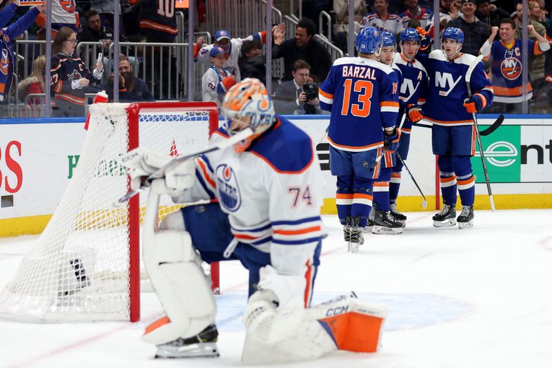 Dec 19, 2023; Elmont, New York, USA; New York Islanders center Bo Horvat (14) celebrates his power play goal against Edmonton Oilers goaltender Stuart Skinner (74) with teammates during the second period at UBS Arena. Mandatory Credit: Brad Penner-USA TODAY Sports