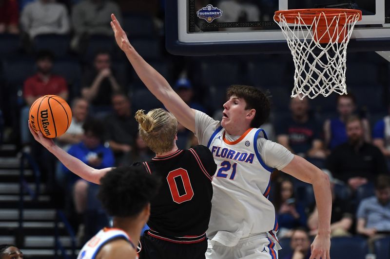 Mar 14, 2024; Nashville, TN, USA; Florida Gators forward Alex Condon (21) tries to defend a shot by Georgia Bulldogs guard Blue Cain (0) during the first half at Bridgestone Arena. Mandatory Credit: Christopher Hanewinckel-USA TODAY Sports