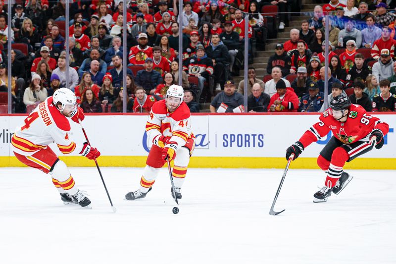 Jan 15, 2026; Chicago, Illinois, USA; Calgary Flames defenseman Joel Hanley (44) defends against Chicago Blackhawks right wing Ilya Mikheyev (95) during the first period at United Center. Mandatory Credit: Kamil Krzaczynski-Imagn Images