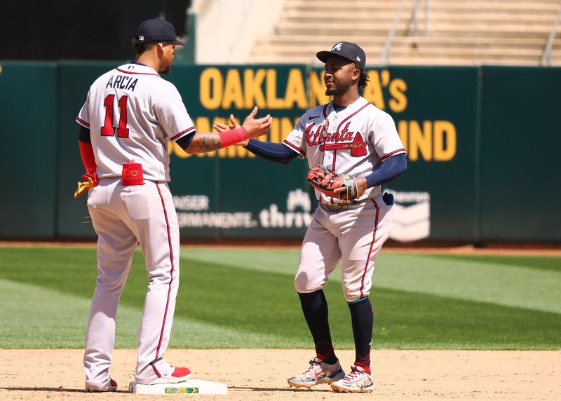 May 31, 2023; Oakland, California, USA; Atlanta Braves shortstop Orlando Arcia (11) and second baseman Ozzie Albies (1) celebrate after a win against the Oakland Athletics at Oakland-Alameda County Coliseum. Mandatory Credit: Kelley L Cox-USA TODAY Sports