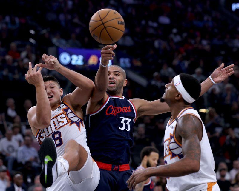 INGLEWOOD, CALIFORNIA - OCTOBER 23: Nicolas Batum #33 of the LA Clippers reaches for a rebound between Grayson Allen #8 and Bradley Beal #3 of the Phoenix Suns during the first half in the season home opening game at Intuit Dome on October 23, 2024 in Inglewood, California. (Photo by Harry How/Getty Images) NOTE TO USER: User expressly acknowledges and agrees that, by downloading and or using this photograph, User is consenting to the terms and conditions of the Getty Images License Agreement. (Photo by Harry How/Getty Images)