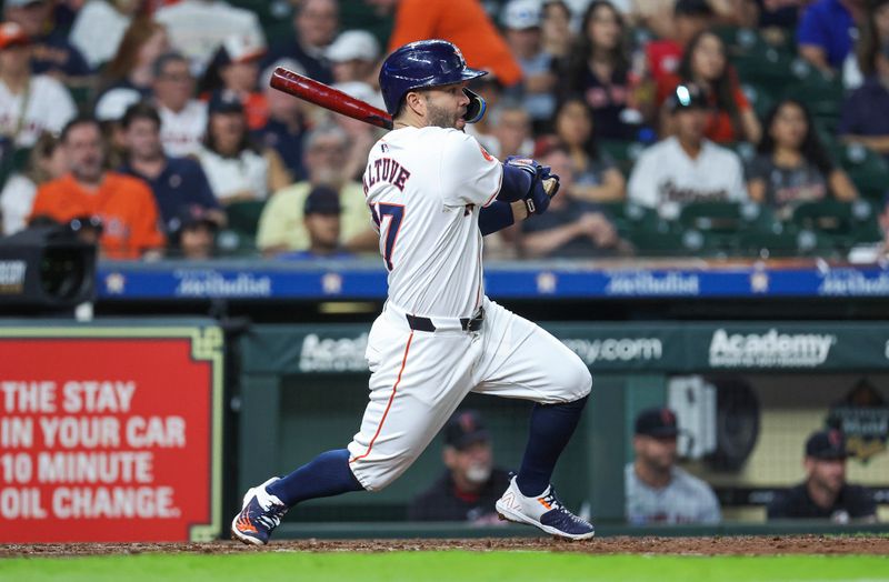 May 2, 2024; Houston, Texas, USA; Houston Astros second baseman Jose Altuve (27) hits a single during the fifth inning against the Cleveland Guardians at Minute Maid Park. Mandatory Credit: Troy Taormina-USA TODAY Sports