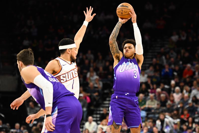 SALT LAKE CITY, UTAH - DECEMBER 13: Keyonte George #3 of the Utah Jazz shoots over Devin Booker #1 of the Phoenix Suns during the first half of a game at Delta Center on December 13, 2024 in Salt Lake City, Utah.  NOTE TO USER: User expressly acknowledges and agrees that, by downloading and or using this photograph, User is consenting to the terms and conditions of the Getty Images License Agreement. (Photo by Alex Goodlett/Getty Images)