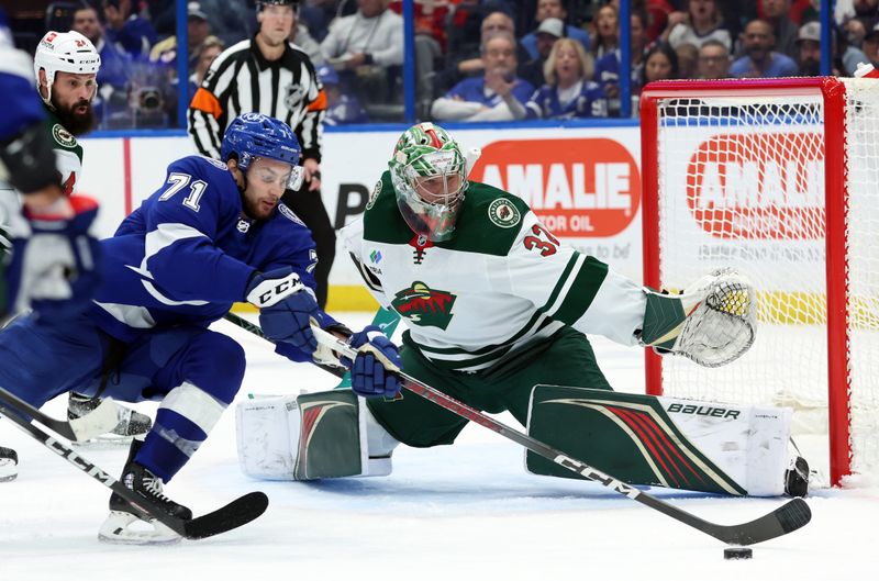 Jan 18, 2024; Tampa, Florida, USA; Minnesota Wild goaltender Filip Gustavsson (32) makes a save as Tampa Bay Lightning center Anthony Cirelli (71) skates during the first period at Amalie Arena. Mandatory Credit: Kim Klement Neitzel-USA TODAY Sports