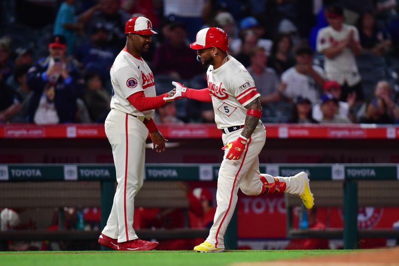 May 27, 2025; Anaheim, California, USA; Los Angeles Angels third baseman Yoan Moncada (5) is greeted by third base coach Bo Porter (88) after hitting a solo home run against the New York Yankees during the ninth inning at Angel Stadium. Mandatory Credit: Gary A. Vasquez-Imagn Images